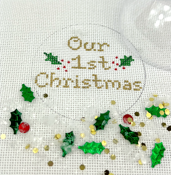 Christmas Ornament w/ Clear Dome Cover & Confetti – “Our 1st  Christmas” w/ Holly – gold letters