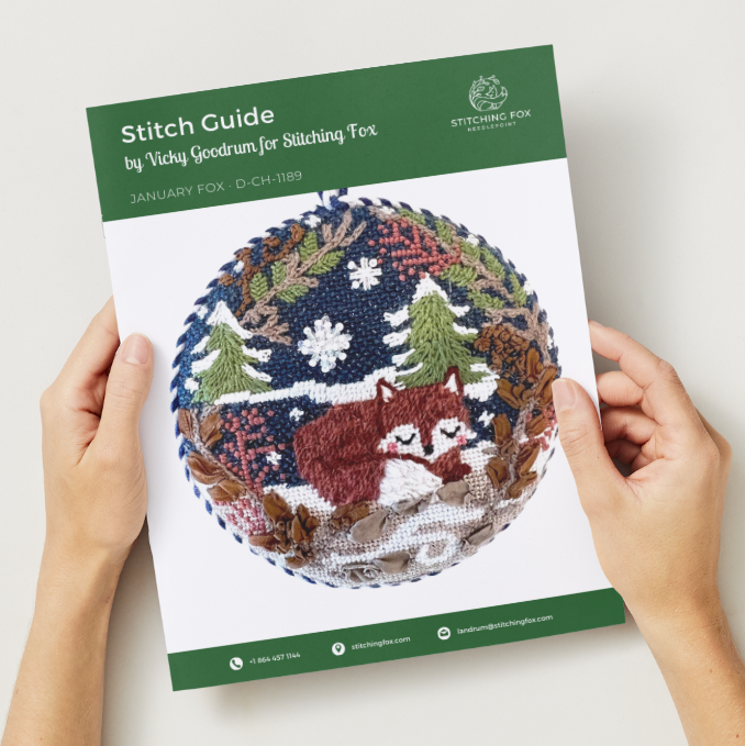 Stitch guide with a fox design held by hands on a white background